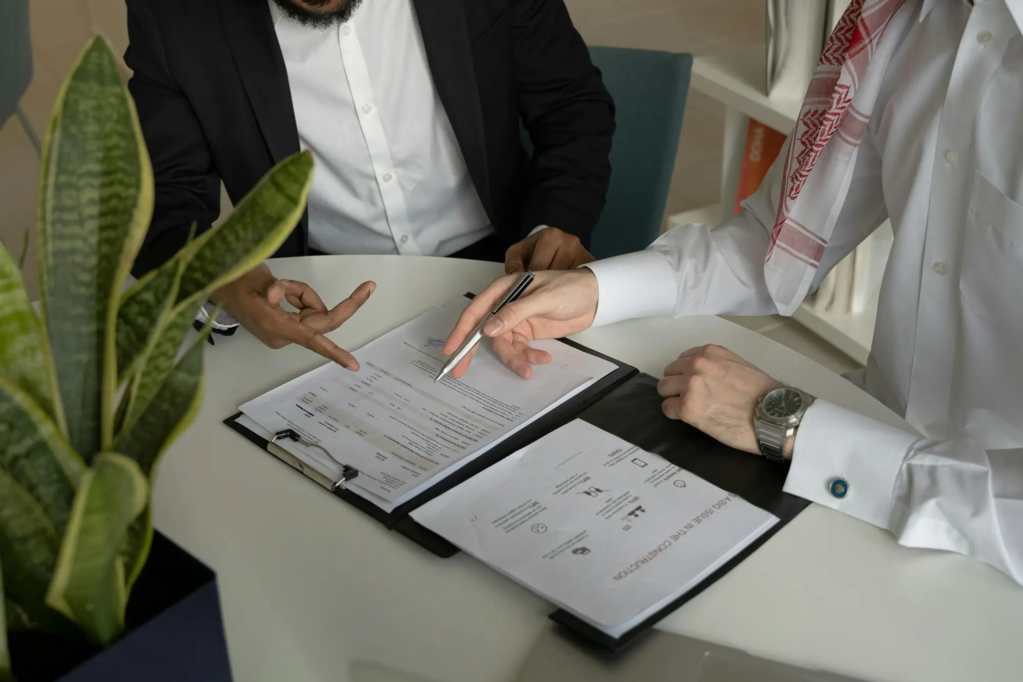 Two directors reviewing and signing documents at a table