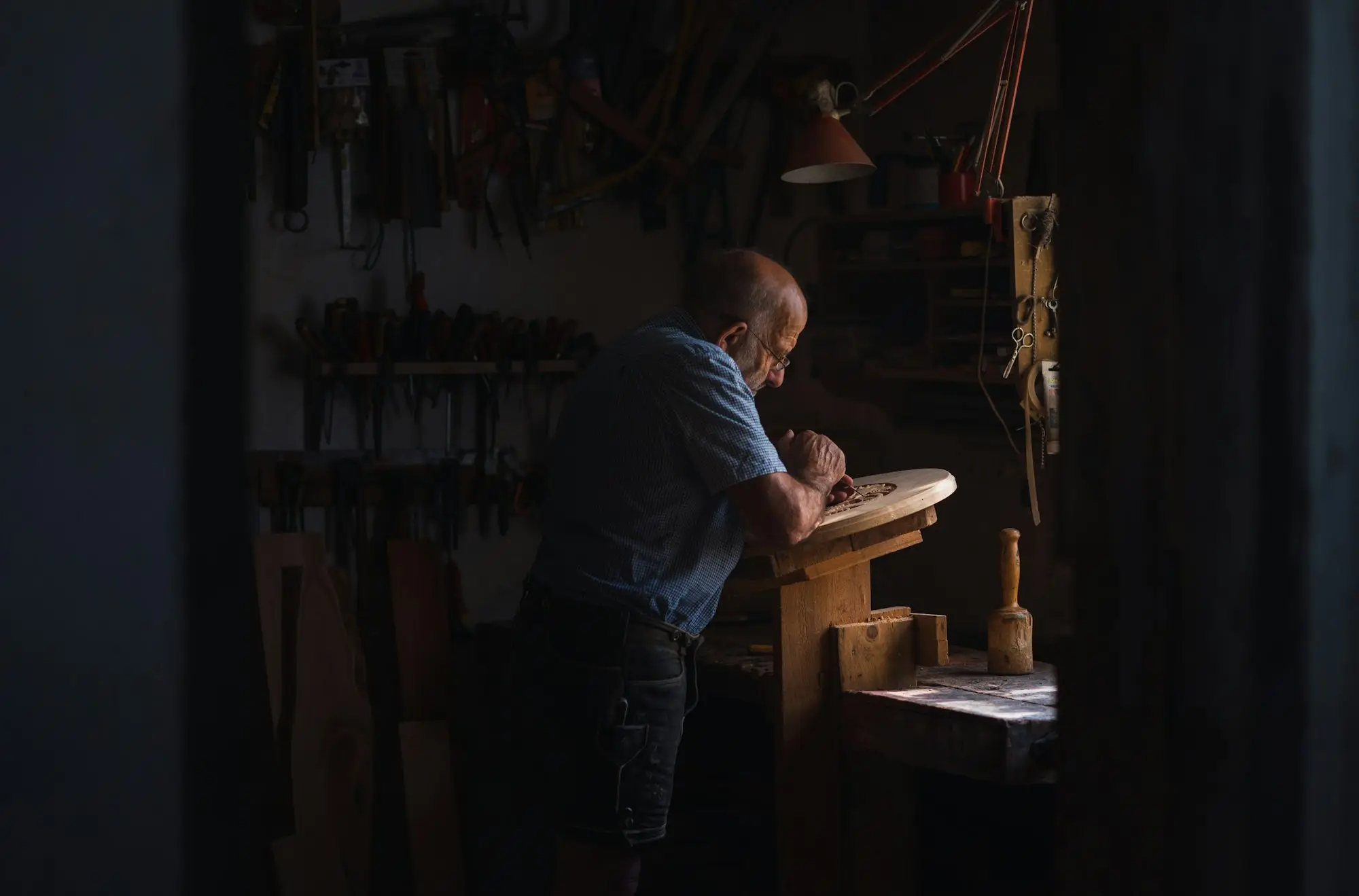 Tradesman working late at his bench in a dimly lit workshop